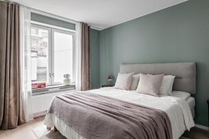 a bedroom with a large bed with a window at Stylish Waterfront Apt Stockholm in Stockholm
