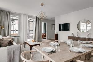 a living room with a dining room table with chairs at Stylish Waterfront Apt Stockholm in Stockholm