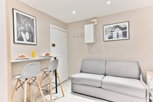 a living room with a couch and two stools at Studio Confortable au cœur du Quartier Sentier in Paris