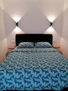 a bedroom with a bed with a blue comforter at Apartman Lamela in Zenica