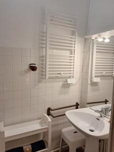 a white bathroom with a sink and a bath tub at Joli T2 BAGNERES de Bigorre Centre in Bagnères-de-Bigorre