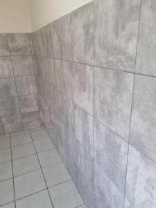 a bathroom with a tiled wall and a shower at Jazreel b&b in Vanderbijlpark +48 photos