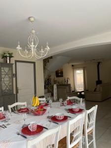 una mesa de comedor con platos rojos y blancos. en Les hortensias, en Les Sables-dʼOlonne