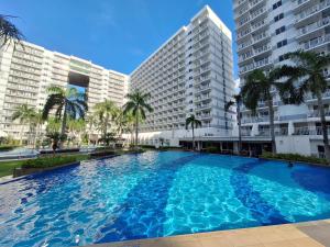 a large swimming pool in front of two buildings at Best staycation at Shell residences in MOA complex in Manila