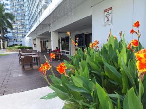 a patio with tables and flowers in front of a building at Best staycation at Shell residences in MOA complex in Manila