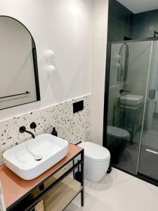 a bathroom with a sink and a toilet and a shower at Stylish Designer Apartment in Mellieħa +15 photos