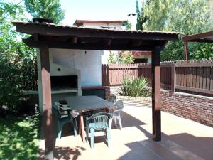 a wooden pergola with a table and chairs on a patio at Alquileres en Piriápolis Coriman & Luz de Luna in Piriápolis