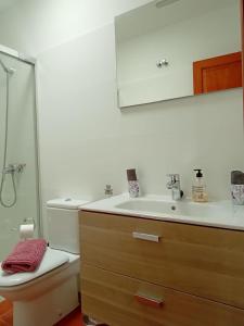 łazienka z umywalką, toaletą i lustrem w obiekcie Villa Erimar w mieście Playa Blanca