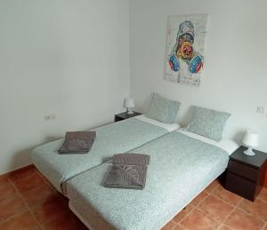 dwa łóżka pojedyncze w pokoju z dwiema lampami w obiekcie Villa Erimar w mieście Playa Blanca