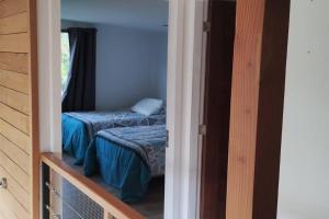 1 dormitorio con 1 cama pequeña en una habitación con puerta en Hermosa casa en parcela, en Puerto Varas