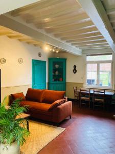 a living room with a couch and a table at La Grange aux Tommies - Pays du Coquelicot in Bus Les Artois