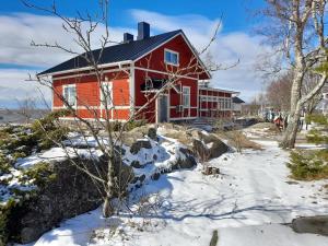 a red house with snow in front of it at Luonnon rauhassa kodikas loma-asunto in Pori