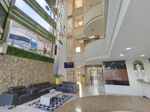 CabudareHotel La Estancia的一个带沙发和石墙的大堂