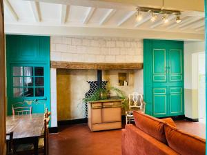 a living room with green walls and a couch and a table at La Grange aux Tommies - Pays du Coquelicot in Bus Les Artois +43 photos