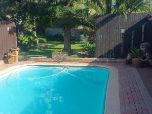 a large blue swimming pool in a yard at Ceelee's Place in Bloemfontein