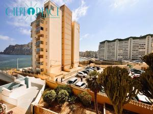 a large building with cars parked in a parking lot at Kenya 1ª Linea in Ifach