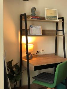 a wooden desk with a lamp and a green chair at Remote work friendly apartment with fast wifi - rooftop and gym in Chiang Mai +38 photos