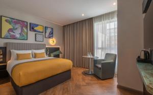 a hotel room with a bed and a chair at Maldron Hotel Brighton City Centre in Brighton & Hove +37 photos