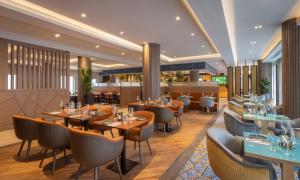 a restaurant with tables and chairs in a room at Maldron Hotel Brighton City Centre in Brighton & Hove