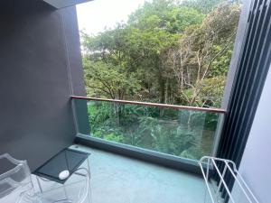 a room with a large window with a view of trees at Emerald Terrace Condo 42- 1 Bed Pool in Patong Beach