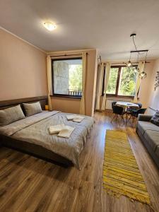 a bedroom with a bed and a couch and a table at BoroHome in Borovets