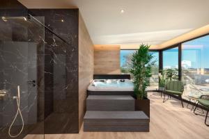 a bathroom with a soaking tub and a table and chairs at Villa Liliana Vodice in Vodice