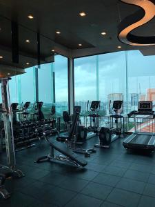 a gym with rows of exercise equipment in a building at Remote work friendly apartment with fast wifi - rooftop and gym in Chiang Mai