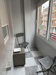 una camera con una sedia, un tavolo e una finestra di Feria Home ad Albacete