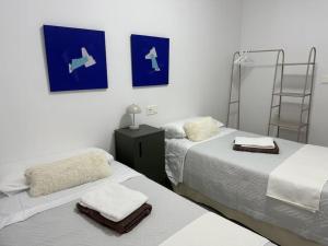 una camera con due letti con asciugamani di Feria Home ad Albacete