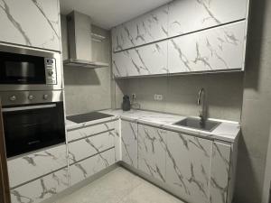 una cucina con ripiani in marmo bianco e lavandino di Feria Home ad Albacete