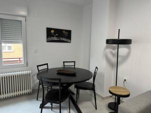 una sala da pranzo con tavolo e sedie neri di Feria Home ad Albacete Altre 5 foto