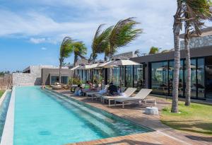 a resort with a swimming pool and palm trees at Koloa Concept Hotel in Barra Grande