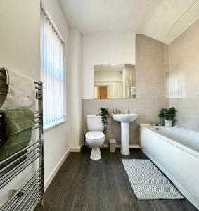 ein Badezimmer mit Badewanne, Toilette und Waschbecken in der Unterkunft Spacious 3-Bedroom Family Home in Ince in Ince-in-Makerfield