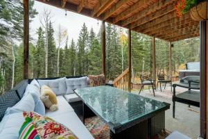 a screened in porch with a couch and a table at Pinetop Cabin Hot Tub BBQ Arcade Scenic Escape in Florissant