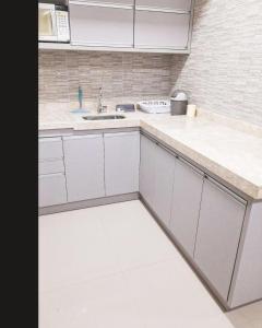 a kitchen with white cabinets and a sink at Parque veredas resort in Rio Quente