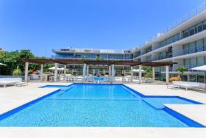 a swimming pool in front of a building at Spacious Magia Condo Steps to the beach & 5th Ave in Playa del Carmen +72 photos