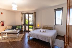 a bedroom with a bed and a couch and a table at Urban Beach I in Portimão