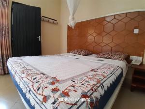 a bed with a quilt on it in a bedroom at Pearl Motel Wing in Mukono