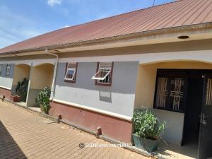 a house with a red roof and a brick street at Pearl Motel Wing in Mukono