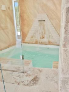 a swimming pool in a room with a glass door at PETRA ANTIQUA in Locorotondo +29 photos