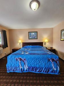 una camera d'albergo con letto e copriletto blu di Mount Laurel Motel a Hazleton