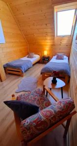 a room with two beds and a couch in a cabin at Hrube DOMKI Zakopane in Zakopane
