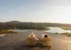 a group of three people sitting in chairs on a balcony at Hoteles Desconecta2 by Vicoba in Monesterio