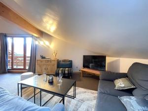 a living room with a couch and a table at Duplex de Charme pour 6 Personnes, Proche Centre et Pistes de Ski - FR-1-505-209 in Notre-Dame-de-Bellecombe