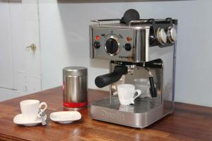 a coffee maker sitting on a table with two cups at Beautiful Listed Townhouse in Beaumaris in Beaumaris