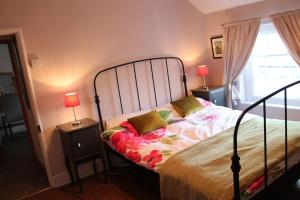 a bedroom with a bed and two lamps on tables at Beautiful Listed Townhouse in Beaumaris in Beaumaris