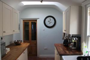 a kitchen with a clock on a white wall at Beautiful Listed Townhouse in Beaumaris in Beaumaris +8 photos