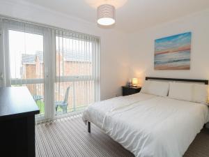 een witte slaapkamer met een bed en een groot raam bij 102 Waterside Park in Lowestoft +16 foto's