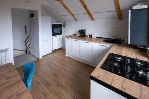 Una cocina con gabinetes blancos y un horno de estufa. en La Bubu Apartament 2, en Zărneşti 24 fotos más