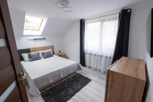 a small bedroom with a bed and a window at Piatra Craiului Retreat in Zărneşti